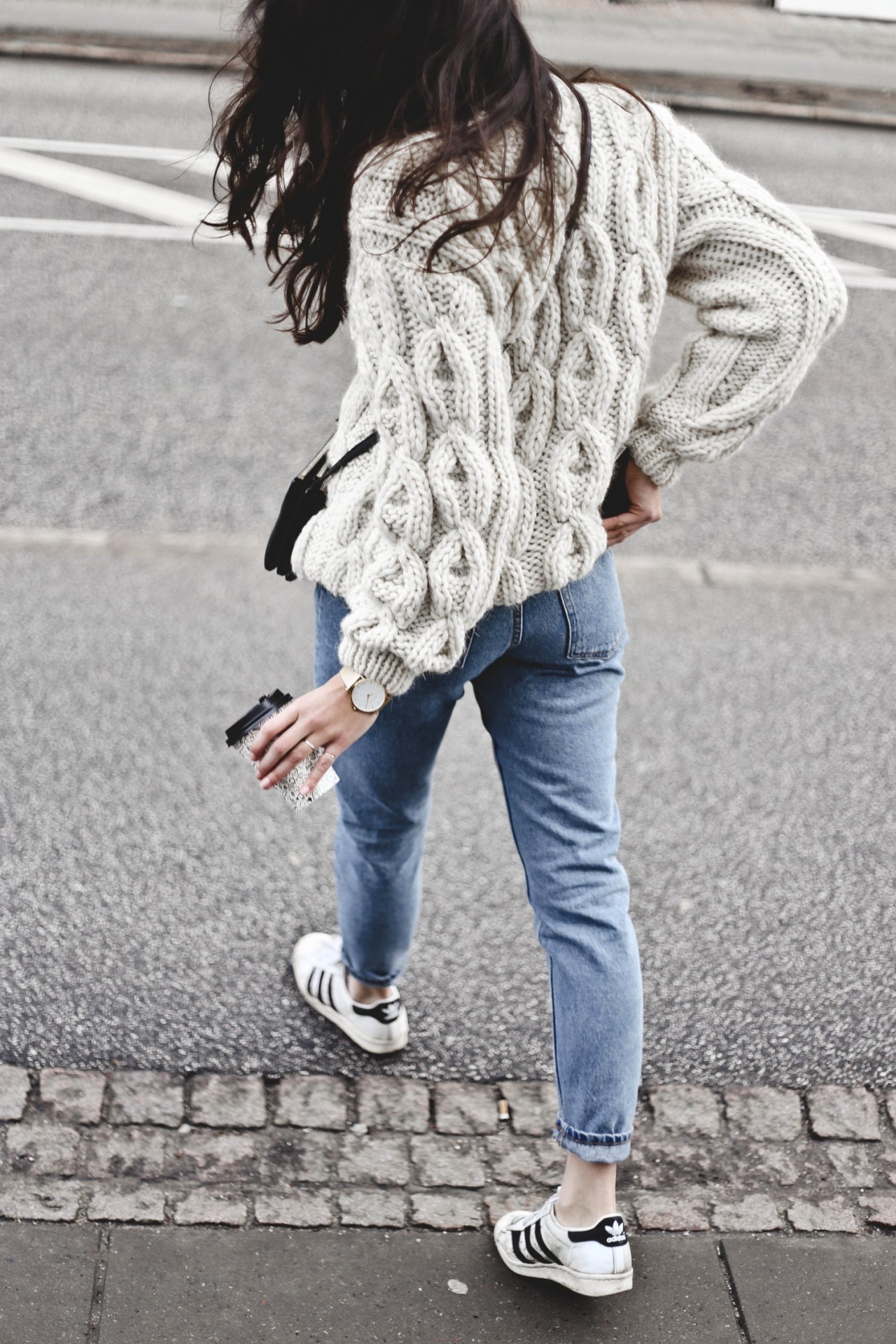 Monja Wormser is working the knitwear trend in this chunky cable knit sweater from Mirstores, which she has paired with simple denim jeans and retro Adidas sneakers. Knit: Mirstores, Jeans: Monki, Sneakers: Adidas, Bag: Celine.