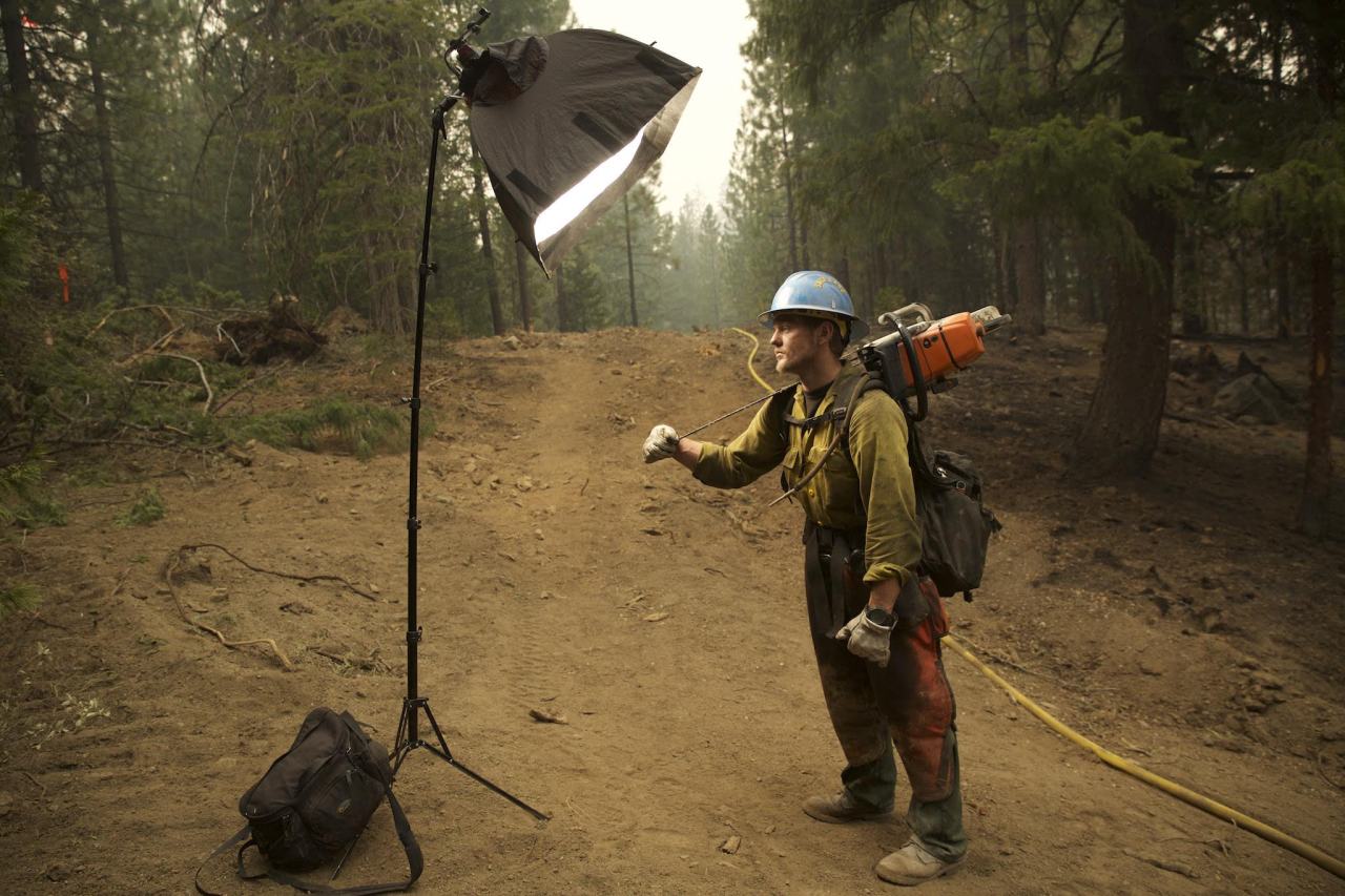 Capturing Portraits on the Fire LineNational Geographic photographer Mark Thiessen is our inside man when it comes to stories about fire. He has photographed several wildfire stories and is a trained firefighter himself. Recently, he embedded with one team fighting a group of fires near Hayfork, California. Go to our sister blog Proof to see all the portraits and read his first-person account about working with the firefighting crew.  During the 20 years I have been shooting wildfires there is one thing that always stands out: the faces. They have that “50-foot stare in a 10-foot room” gaze. Who could blame them after working 21 days straight? A few weeks ago I spent a week with a hand crew from the Salt Lake Unified Fire Authority. (See the story on Nat Geo News, A Photographer Inside the Wildfires ) Although they usually work 14 days, they were extended to 21 because it was such a frantic fire season. Three weeks of hard work in hot, dusty, smoky conditions—combined with accumulated sleep deprivation—can really take its toll, and it shows on their faces.Here&rsquo;s how I capture these portraits on the fire line. First I look for a background that has some depth and the residual smoke of a burned-out area helps with this effect. Next I set up a soft box with a Canon Speedlite 600-EX-RT strobe inside. This is the same kind of strobe you would place on top of your camera, but I’m putting it in a softbox. For those who don’t know, a softbox is kind of like a tent that diffuses the light. The larger the softbox, the softer the light. I placed the softbox on a light stand pointing at the subject and shot below it.[fusion_builder_container hundred_percent=