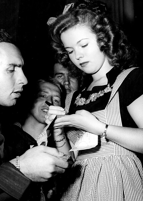 oldhollywood-glamour:

Shirley Temple signing autographs for servicemen at the Hollywood Canteen. 1940’s

